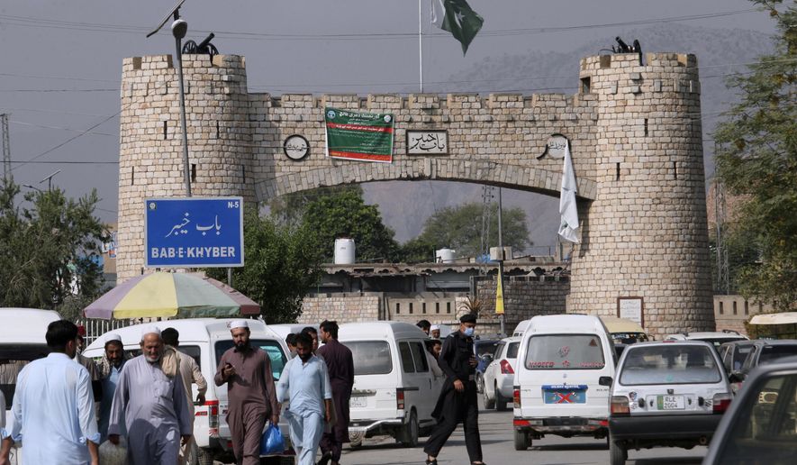 People walk while vehicle move through historical Khyber Pass in Jamrud, the main town of Pakistan&#39;s Khyber district bordering Afghanistan, Monday, Oct. 11, 2021. (AP Photo/Muhammad Sajjad)