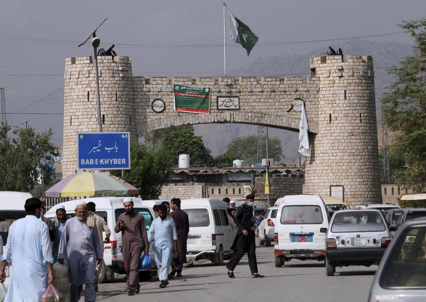People walk while vehicle move through historical Khyber Pass in Jamrud, the main town of Pakistan&#39;s Khyber district bordering Afghanistan, Monday, Oct. 11, 2021. (AP Photo/Muhammad Sajjad)