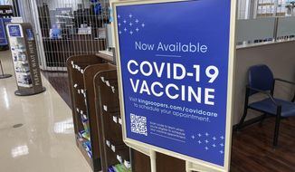 In this Saturday, Oct. 23, 2021, photograph, a sign notifies customers that COVID-19 vaccinations are available at a pharmacy in a grocery store in Monument, Colo. Millions of U.S. workers now have a Jan. 4 deadline to get a COVID-19 vaccine. The federal government on Thursday, Nov. 4, 2021 announced new vaccine requirements for workers at companies with more than 100 employees. (AP Photo/David Zalubowski)