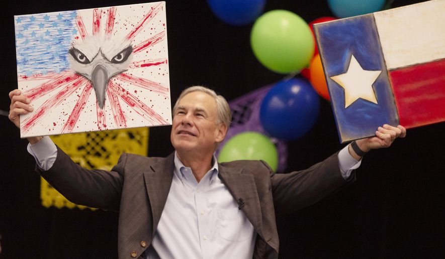 Gov. Greg Abbott holds up two paintings he received as a gift at the Midland Chapter of the Republican National Hispanic Assembly&#39;s Reagan Lunch at the Bush Convention Center, Friday, Nov. 5, 2021, in Midland, Texas. (Jacob Ford/Odessa American via AP) **FILE**