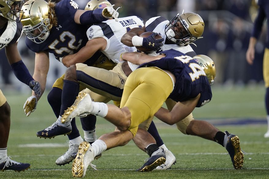 Notre Dame linebacker Kahanu Kia (44) tackles Navy fullback Maquel Haywood (24) in the second half of an NCAA college football game in South Bend, Ind., Saturday, Nov. 6, 2021. (AP Photo/Paul Sancya)