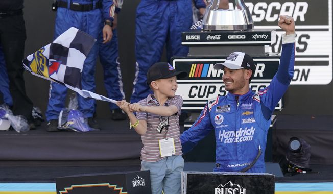 Kyle Larson and his son Owen celebrate after winning a NASCAR Cup Series auto race and championship on Sunday, Nov. 7, 2021, in Avondale, Ariz. (AP Photo/Rick Scuteri) **FILE**