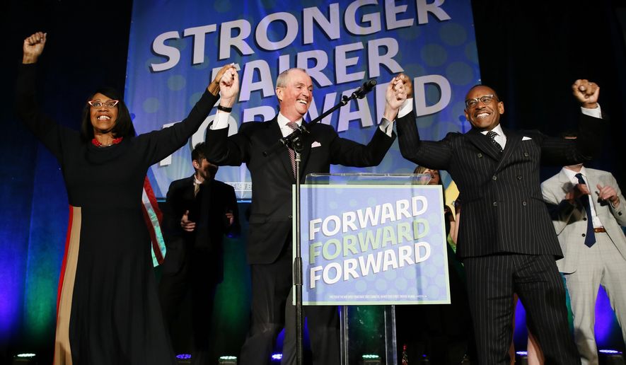 Lt. Gov. Sheila Oliver, left, New Jersey Gov. Phil Murphy, center, and LeRoy Jones, chairman of the state&#39;s Democratic committee, right, celebrate at Convention Hall after Murphy won the gubernatorial race against Jack Ciattarelli, Wednesday, Nov. 3, 2021, in Asbury Park, N.J. (AP Photo/Noah K. Murray)
