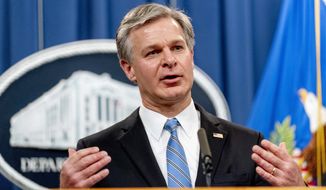 FBI Director Christopher Wray speaks at a news conference at the Justice Department in Washington, Monday, Nov. 8, 2021. Two suspected criminal hackers have been charged in the United States in connection with a wave of ransomware attacks. That includes one that led to the temporary shutdown of the world’s largest meat processor and another that snarled businesses around the globe on the Fourth of July weekend. Attorney General Merrick Garland and other top officials announced charges Monday against Ukrainian Yaroslav Vasinskyi and Russian Yevgeniy Polyanin, alleging them to be part of the REvil ransomware gang.  (AP Photo/Andrew Harnik)