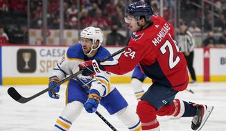 Washington Capitals center Connor McMichael, right, scores a goal in front of Buffalo Sabres left wing Vinnie Hinostroza in the second period of an NHL hockey game, Monday, Nov. 8, 2021, in Washington. (AP Photo/Patrick Semansky)
