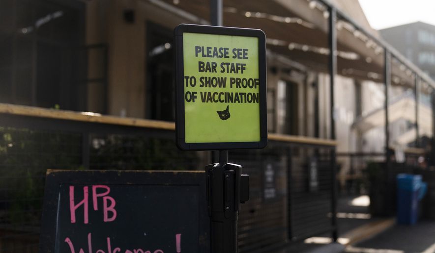 A sign asking customers to show proof of COVID-19 vaccination stands outside Highland Park Brewery Monday, Nov. 8, 2021, in Los Angeles. Starting Monday, anyone going to a shopping mall, theater, gym or nail salon in Los Angeles must verify they are vaccinated. The mandate, among the strictest in the country, requires proof of shots for everyone entering a wide variety of businesses. (AP Photo/Jae C. Hong)