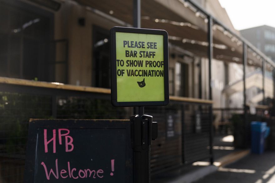 A sign asking customers to show proof of COVID-19 vaccination stands outside Highland Park Brewery Monday, Nov. 8, 2021, in Los Angeles. Starting Monday, anyone going to a shopping mall, theater, gym or nail salon in Los Angeles must verify they are vaccinated. The mandate, among the strictest in the country, requires proof of shots for everyone entering a wide variety of businesses. (AP Photo/Jae C. Hong)