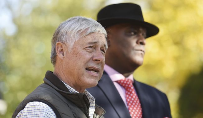 Rep. Fred Upton, R-St. Joseph, left and Benton Harbor Mayor Marcus Muhammad hold a press conference at a home along Ogden Avenue in Benton Harbor, Mich., on Monday, Nov. 8, 2021, to talk about the lead line replacement in Benton Harbor. City residents continue to use bottled water for drinking and cooking as a number of homes have been found to have elevated lead levels in the water lines. (Don Campbell/The Herald-Palladium via AP)