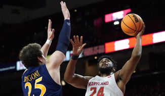 Maryland forward Donta Scott (24) goes up for a shot against Quinnipiac forward Jacob Rigoni (25) during the first half of an NCAA college basketball game, Tuesday, Nov. 9, 2021, in College Park, Md. (AP Photo/Julio Cortez)