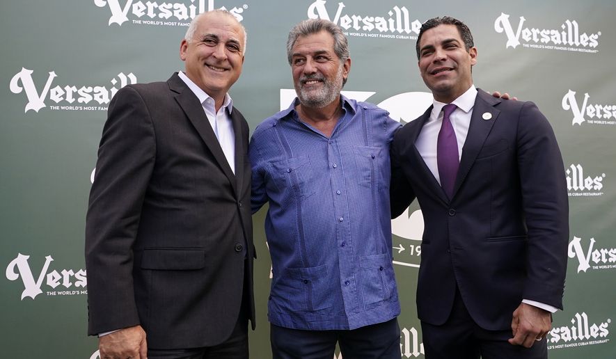 Versailles Restaurant owner Felipe Valls Jr., center, poses for a photograph with Hialeah Mayor Esteban Bovo, left, and Miami Mayor Francis Suarez, right, as the restaurant celebrates its 50th anniversary, Wednesday, Nov. 10, 2021, in Miami. The iconic Cuban restaurant is a popular meeting place for the Cuban exile community, as well as politicians and presidents of both political parties. (AP Photo/Lynne Sladky)