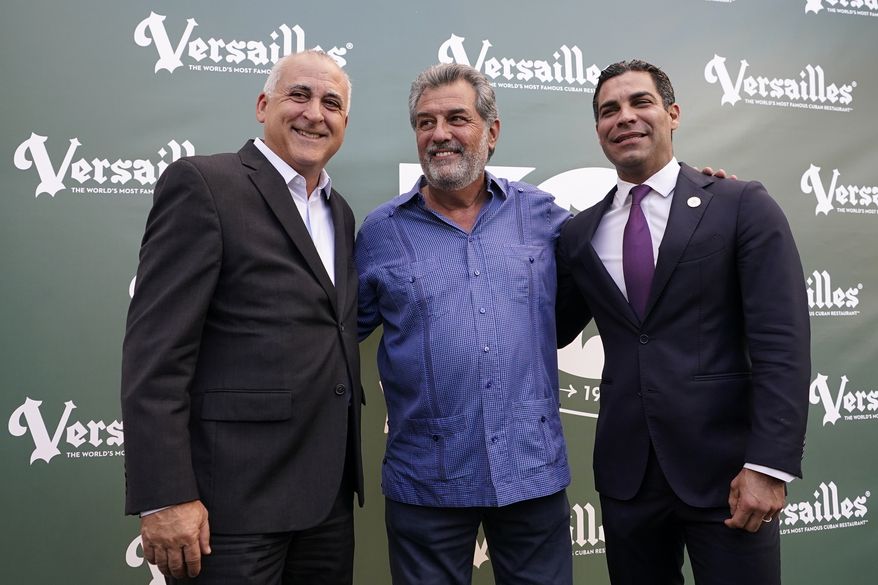 Versailles Restaurant owner Felipe Valls Jr., center, poses for a photograph with Hialeah Mayor Esteban Bovo, left, and Miami Mayor Francis Suarez, right, as the restaurant celebrates its 50th anniversary, Wednesday, Nov. 10, 2021, in Miami. The iconic Cuban restaurant is a popular meeting place for the Cuban exile community, as well as politicians and presidents of both political parties. (AP Photo/Lynne Sladky)