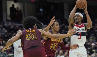 Washington Wizards&#39; Bradley Beal (3) looks to pass against Cleveland Cavaliers&#39; Isaac Okoro (35) and Jarrett Allen (31) in the second half of an NBA basketball game, Wednesday, Nov. 10, 2021, in Cleveland. (AP Photo/Tony Dejak)