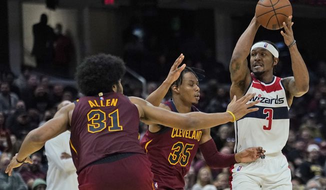 Washington Wizards&#x27; Bradley Beal (3) looks to pass against Cleveland Cavaliers&#x27; Isaac Okoro (35) and Jarrett Allen (31) in the second half of an NBA basketball game, Wednesday, Nov. 10, 2021, in Cleveland. (AP Photo/Tony Dejak)
