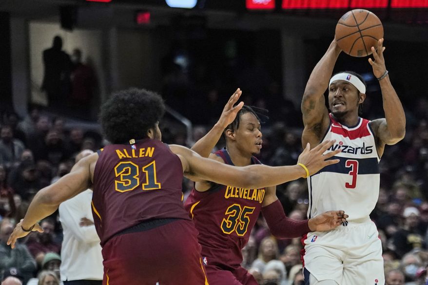 Washington Wizards&#39; Bradley Beal (3) looks to pass against Cleveland Cavaliers&#39; Isaac Okoro (35) and Jarrett Allen (31) in the second half of an NBA basketball game, Wednesday, Nov. 10, 2021, in Cleveland. (AP Photo/Tony Dejak)