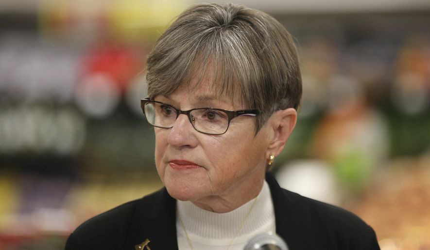 Kansas Gov. Laura Kelly wears an ax pin on her lapel to symbolize her plan to eliminate the state&#39;s 6.5% sales tax on groceries during a news conference, Monday, Nov. 8, 2021, in the produce section of a Dillons grocery in Topeka, Kan. (AP Photo/John Hanna) ** FILE **