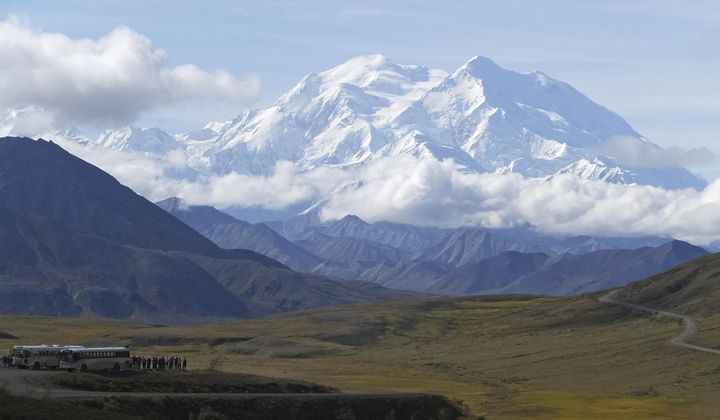 Sightseeing buses and tourists are seen at a pullout popular for taking in views of North America&#x27;s tallest peak, Denali, in Denali National Park and Preserve, Alaska, on Aug. 26, 2016. (AP Photo/Becky Bohrer, File)