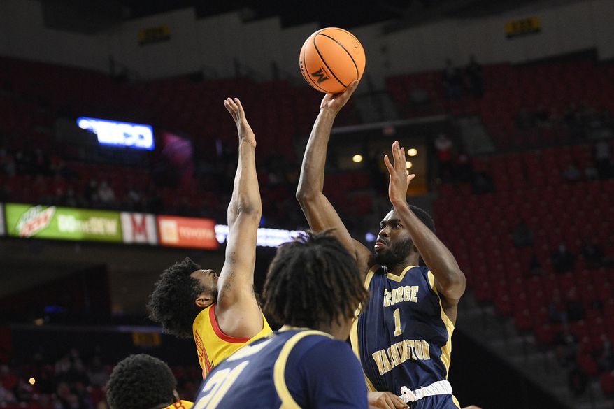 George Washington guard Joe Bamisile (1) shoots against Maryland forward Donta Scott, left, during the first half of an NCAA college basketball game, Thursday, Nov. 11, 2021, in College Park, Md. (AP Photo/Nick Wass) ** FILE **