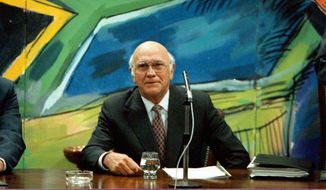 Former President and leader of the National Party F.W. de Klerk, discusses his resignation, below a mural of the new South African flag, at a National Party Caucus meeting in Cape Town, Aug. 26 1997.  F.W. de Klerk, who oversaw the end of South Africa&#39;s country’s White minority rule, has died at 85 it was announced Thursday, Nov. 11, 2021. (AP Photo/Sasa Kralj, File)
