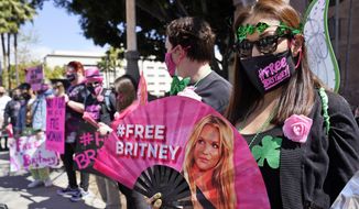 FILE - Britney Spears supporter Kiki Norberto holds a hand fan outside a court hearing concerning the pop singer&#39;s conservatorship at the Stanley Mosk Courthouse on March 17, 2021, in Los Angeles. A judge this week could end the conservatorship that has controlled Britney Spears&#39; life and money for nearly 14 years. (AP Photo/Chris Pizzello, File)