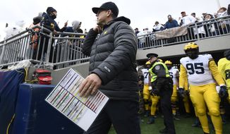 Michigan head coach Jim Harbaugh takes the field with his players from an NCAA college football game against Penn State in State College, Pa.on Saturday, Nov. 13, 2021. (AP Photo/Barry Reeger)