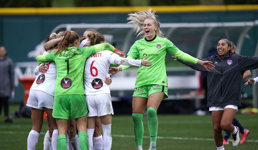 Washington Spirit players celebrate after defeating the OL Reign in the semifinals of the NWSL soccer playoffs Sunday, Nov. 14, 2021, in Tacoma, Wash. The Spirit won 2-1. (AP Photo/Elaine Thompson)