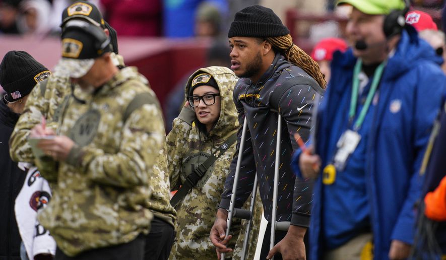 Washington Football Team defensive end Chase Young uses crutches on the sideline during the second half of an NFL football game against the Tampa Bay Buccaneers, Sunday, Nov. 14, 2021, in Landover, Md. (AP Photo/Nick Wass)