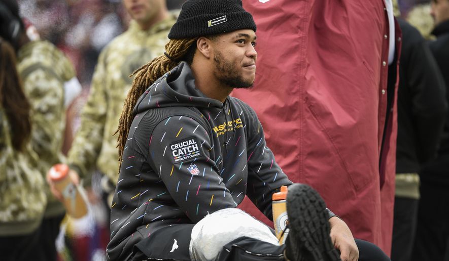 Washington Football Team defensive end Chase Young sits in the bench area with ice on his leg during the second half of an NFL football game against the Tampa Bay Buccaneers, Sunday, Nov. 14, 2021, in Landover, Md. (AP Photo/Mark Tenally)