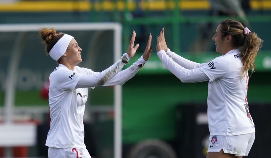 Washington Spirit&#39;s Trinity Rodman, left, is congratulated by teammate Sam Staab after scoring against the OL Reign in the first half in the semifinals of the NWSL soccer playoffs Sunday, Nov. 14, 2021, in Tacoma, Wash. (AP Photo/Elaine Thompson)
