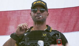 In this Sept. 26, 2020, file photo, Proud Boys leader Henry &quot;Enrique&quot; Tarrio wears a hat that says The War Boys during a rally in Portland, Ore. Complaining about jail conditions, the top leader of the Proud Boys far-right extremist group asked a judge on Monday, Nov. 15, 2021, to free him before he finishes serving a five-month sentence for burning a Black Lives Matter banner taken from a historic Black church in Washington (AP Photo/Allison Dinner, File)