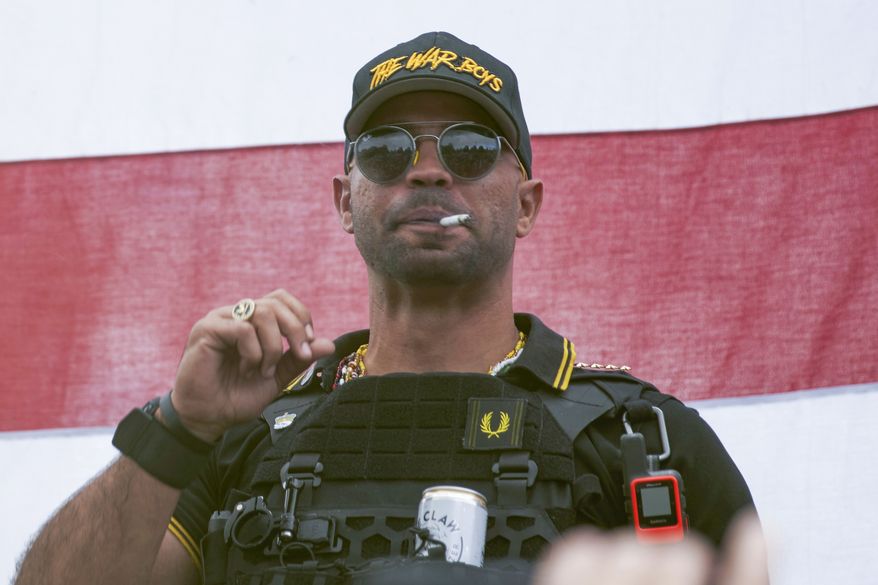 In this Sept. 26, 2020, file photo, Proud Boys leader Henry &quot;Enrique&quot; Tarrio wears a hat that says The War Boys during a rally in Portland, Ore. Complaining about jail conditions, the top leader of the Proud Boys far-right extremist group asked a judge on Monday, Nov. 15, 2021, to free him before he finishes serving a five-month sentence for burning a Black Lives Matter banner taken from a historic Black church in Washington (AP Photo/Allison Dinner, File)