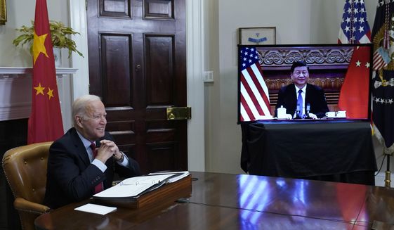 President Joe Biden, left, speaks as he meets virtually with Chinese President Xi Jinping, on screen, from the Roosevelt Room of the White House in Washington, Monday, Nov. 15, 2021. (AP Photo/Susan Walsh)