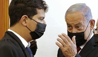 Former Israeli Prime Minister Benjamin Netanyahu, right, arrives for a court hearing on corruption charges Tuesday, Nov. 16, 2021, in Jerusalem. Netanyahu appeared in court for the first time in over half a year on Tuesday as a one-time confidant prepared to take the stand against him in a high-profile corruption case against the former Israeli prime minister. (Jack Guez/Pool Photo via AP)