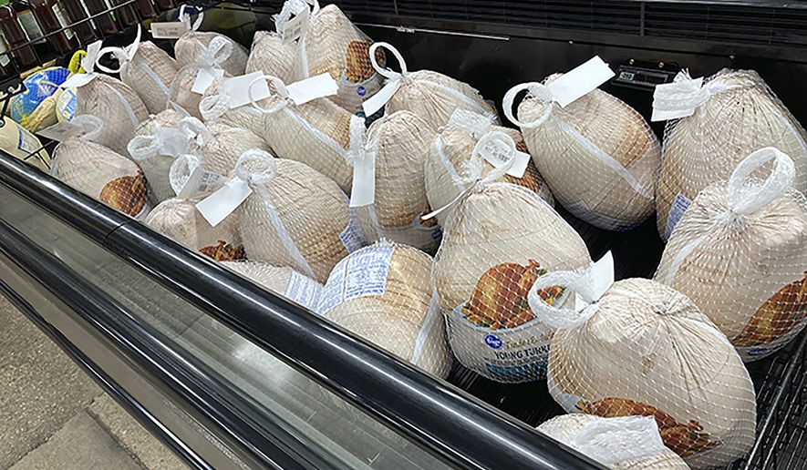 Frozen turkeys sit in a refrigerated case Wednesday, Nov. 17, 2021, inside a grocery store in southeast Denver. (AP Photo/David Zalubowski)