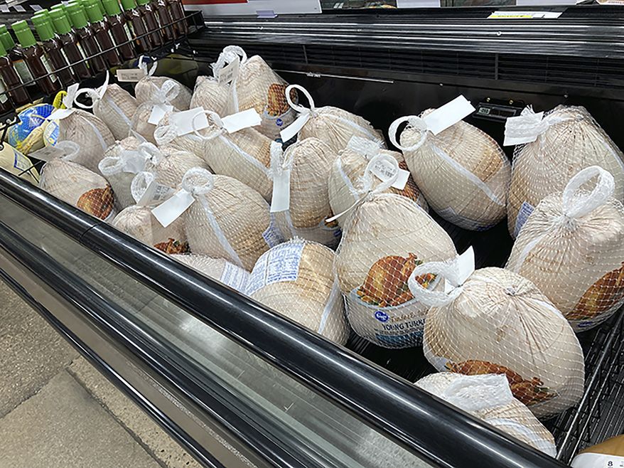 Frozen turkeys sit in a refrigerated case Wednesday, Nov. 17, 2021, inside a grocery store in southeast Denver. (AP Photo/David Zalubowski)