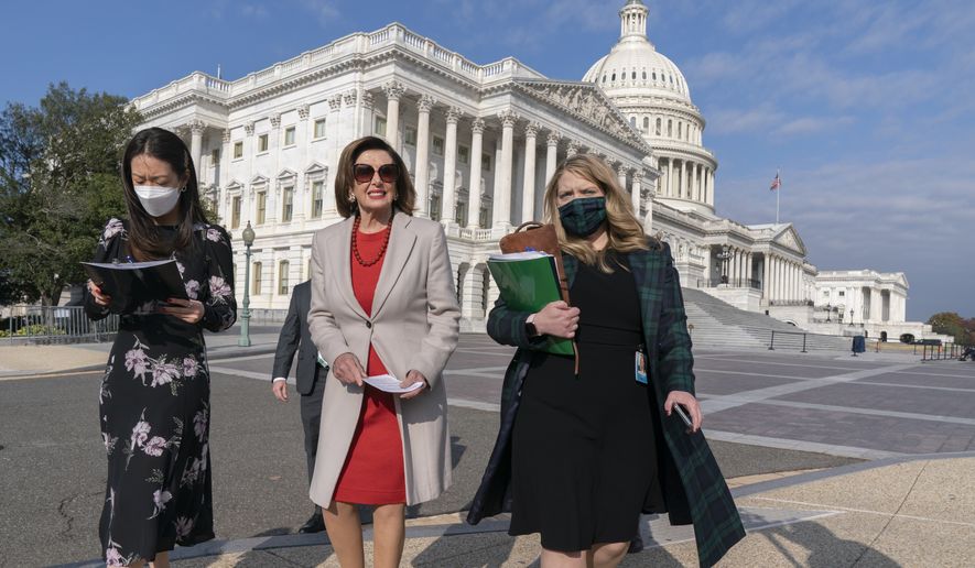 Speaker of the House Nancy Pelosi, D-Calif., center, walks with staff to a news conference to talk about the importance of climate change policy in President Joe Biden&#39;s domestic agenda, Wednesday, Nov. 17, 2021, at the Capitol in Washington. (AP Photo/Jacquelyn Martin)
