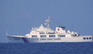 In this photo provided by the Philippine Coast Guard, a Chinese Coast Guard vessel is seen patrolling in the South China Sea, taken sometime April 13-14, 2021. Chinese coast guard ships blocked and used water cannons on two Philippine supply boats heading to a disputed shoal occupied by Filipino marines in the South China Sea, provoking an angry protest against China and a warning from the Philippine government that its vessels are covered under a mutual defense treaty with the U.S., Manila’s top diplomat said Thursday, Nov. 18, 2021. (Philippine Coast Guard via AP)