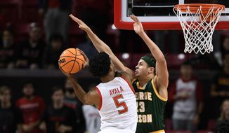 Maryland guard Eric Ayala (5) goes to the basket against George Mason forward Josh Oduro (13) during the first half of an NCAA college basketball game Wednesday, Nov. 17, 2021, in College Park, Md. (AP Photo/Nick Wass)