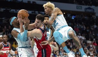 Charlotte Hornets forward Jalen McDaniels (6) and Washington Wizards forward Deni Avdija (9) fight for the ball with Charlotte Hornets guard Kelly Oubre Jr. (12) defending during the second half of an NBA basketball game in Charlotte, N.C., Wednesday, Nov. 17, 2021. (AP Photo/Jacob Kupferman)