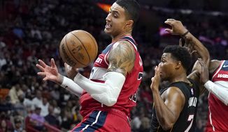 Washington Wizards forward Kyle Kuzma, left, and Miami Heat guard Kyle Lowry (7) go for a loose ball during the second half of an NBA basketball game, Thursday, Nov. 18, 2021, in Miami. The Heat won 112-97. (AP Photo/Lynne Sladky)