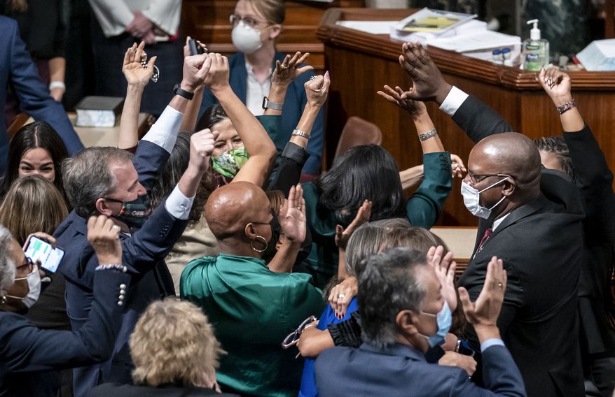 Democrats celebrate in the chamber as the House approves a sweeping social and environment bill, giving a victory to President Joe Biden, at the Capitol in Washington, Friday, Nov. 19, 2021. (AP Photo/J. Scott Applewhite)