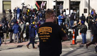 A man wearing an Oath Keepers shirt stands outside the Kenosha County Courthouse, Friday, Nov. 19, 2021 in Kenosha, Wis. Kyle Rittenhouse was acquitted of all charges after pleading self-defense in the deadly Kenosha shootings that became a flashpoint in the nation&#39;s debate over guns, vigilantism and racial injustice. (AP Photo/Paul Sancya)