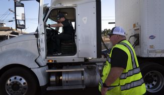 Student driver Luis Barrientos, left, gets on a truck as instructor Daniel Osborne watches at California Truck Driving Academy in Inglewood, Calif., Monday, Nov. 15, 2021. (AP Photo/Jae C. Hong) ** FILE **