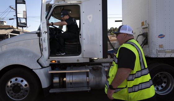 Student driver Luis Barrientos, left, gets on a truck as instructor Daniel Osborne watches at California Truck Driving Academy in Inglewood, Calif., Monday, Nov. 15, 2021. (AP Photo/Jae C. Hong) ** FILE **