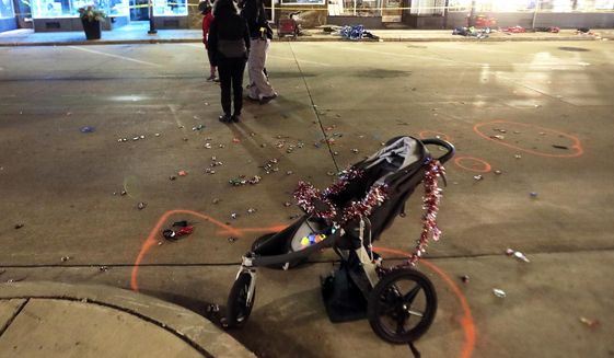 A broken children&#39;s stroller lays on W. Main St. in downtown Waukesha, Wis., after an SUV drove into a parade of Christmas marchers Sunday, Nov. 21, 2021. (John Hart/Wisconsin State Journal via AP)
