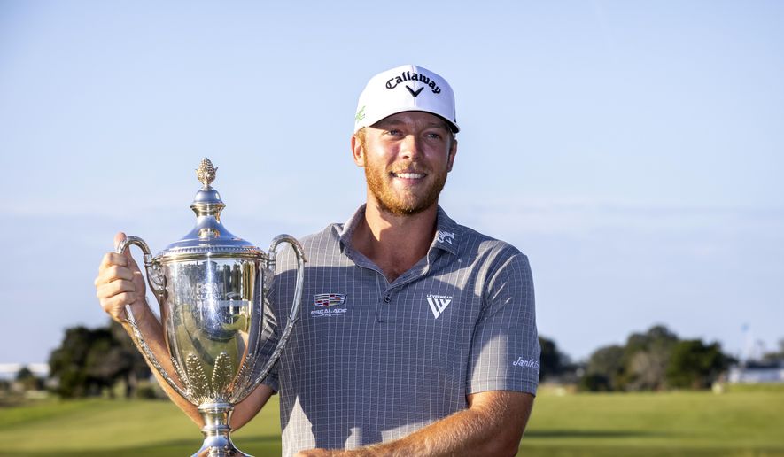 Talor Gooch holds the championship trophy after the final round of the RSM Classic golf tournament, Sunday, Nov. 21, 2021, in St. Simons Island, Ga. (AP Photo/Stephen B. Morton)