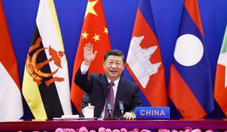 In this photo released by Xinhua News Agency, Chinese President Xi Jinping waves as he chairs the ASEAN-China Special Summit to commemorate the 30th Anniversary of ASEAN-China Dialogue Relations via video link from Beijing, China on Monday, Nov. 22, 2021. Xi on Monday said his country will not seek dominance over Southeast Asia or bully its smaller neighbors, amid ongoing friction over the South China Sea. (Huang Jingwen/Xinhua via AP)