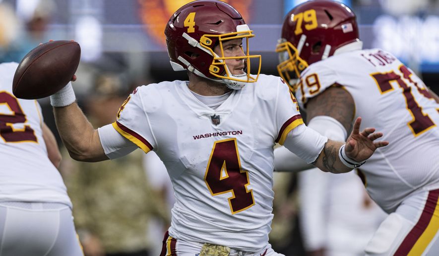 Washington Football Team quarterback Taylor Heinicke (4) looks to pass against the Carolina Panthers during an NFL football game Sunday, Nov. 21, 2021, in Charlotte, N.C. (AP Photo/Jacob Kupferman)