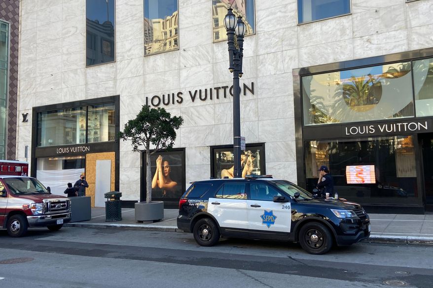 FILE - Police officers and emergency crews park outside the Louis Vuitton store in San Francisco&#39;s Union Square on Nov. 21, 2021, after looters ransacked businesses. Groups of thieves, some carrying crowbars and hammers, smashed glass cases and window displays, ransacking high-end stores throughout the San Francisco Bay Area, stealing jewelry, sunglasses, suitcases and other merchandise before fleeing in waiting cars during a weekend of brazen organized theft that shocked holiday shoppers and prompted concerns about the busy retail season. (Danielle Echeverria/San Francisco Chronicle via AP, File)