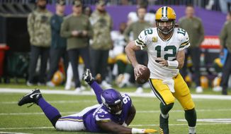 Green Bay Packers quarterback Aaron Rodgers (12) runs from Minnesota Vikings defensive tackle Dalvin Tomlinson (94) during the second half of an NFL football game, Sunday, Nov. 21, 2021, in Minneapolis. (AP Photo/Bruce Kluckhohn) **FILE**