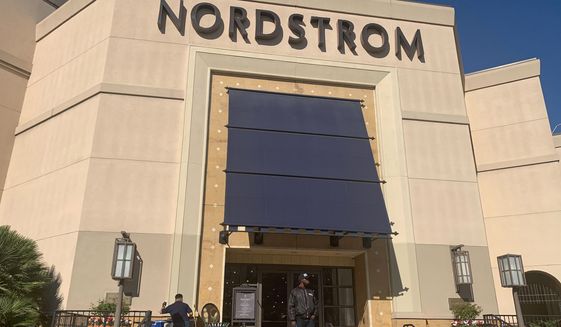 A security guard stands outside the Nordstrom store at The Grove retail and entertainment complex in Los Angeles, Tuesday, Nov. 23, 2021. Los Angeles police say a group of thieves smashed windows at the department store at the luxury mall late Monday, the latest incident in a trend of smash-and-grab crimes is part of a national trend. (AP Photo/Eugene Garcia)
